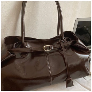 Detail of coffee brown oil wax leather tote bag with thin straps and gold hardware