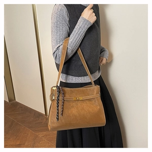 Dettaglio della borsa tote marrone vintage con chiusura a rotazione in metallo e corda