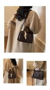Détail du sac bandoulière en cuir marron foncé avec perles décoratives et fermoir