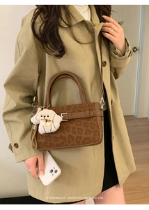 Sac à main rétro léopard avec breloque en peluche sur un trench-coat kaki élégant
