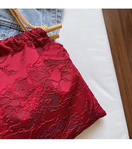 Detail of red rose jacquard fabric and vintage bamboo handle on a retro handbag