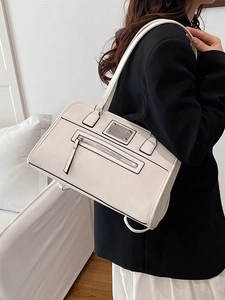 Minimalist beige leather tote bag with black trim and metal hardware for women