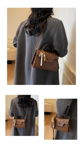 Détail du sac à bandoulière en cuir mat marron vintage avec charm en perles de bois