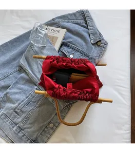 Internal view of red satin handbag with bamboo handle showing spacious interior compartment