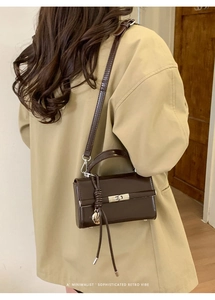 Close-up of deep brown lychee texture PU leather shoulder strap with gold metal D-ring buckle