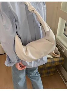 Close-up of white lychee pattern leather shoulder bag with unique knotted strap detail
