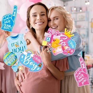 Friends using gender reveal party photo props with team boy and girl paper signs