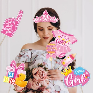 Pink gender reveal party photo props set with baby girl theme held by a pregnant woman