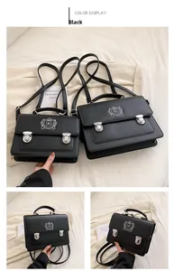 Detail view of black vintage satchels with shield embroidery and silver buckles