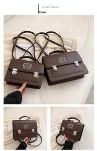 Detailed close-up of brown vintage messenger bag with shield emblem and silver buckles