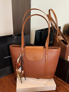 Retro color-block tote bag in brown faux leather with a cute bear charm on a wooden table