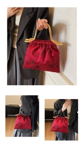 Detail of red Chinese retro handbag with satin embroidery and natural bamboo handle