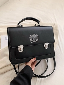 Vintage black crossbody satchel with silver shield emblem and dual metal buckle closures
