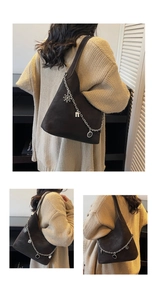 Detailed view of dark brown suede bucket bag with silver snowflake and arch charms