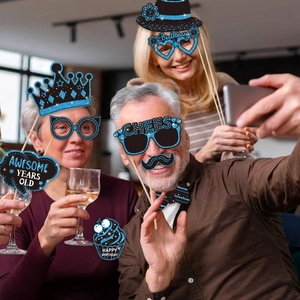 Three people holding blue glitter birthday photo props during a fun indoor party scene