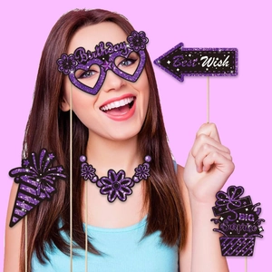 Detail of glitter purple birthday photo props including glasses and gift box held by model
