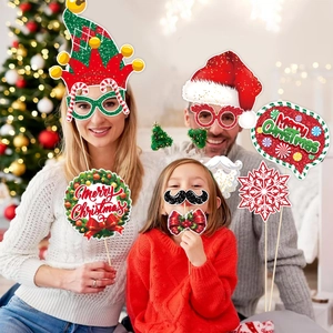 Family using Christmas photo booth props with Santa hats and Merry Christmas signs