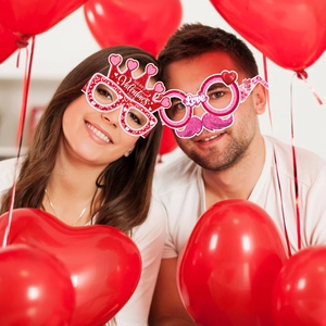 Detail of paper Valentine's Day party glasses with heart and crown designs for photo props