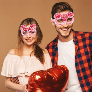 Glittery pink heart-shaped party glasses with love text for Valentine's Day photo props