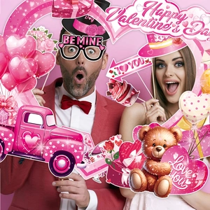 Couple holding colorful Valentine's Day party photo booth props and paper glasses