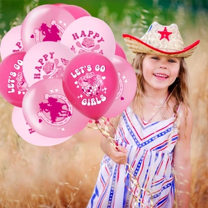 Ballons roses de fête cow-girl aux motifs western tenus par une fille dans un champ