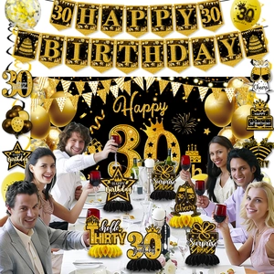 Dettaglio set 30° compleanno nero e oro con striscioni e centrotavola a nido d'ape