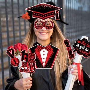 Close-up of funny 2026 graduation photo props with red glitter and GRAD glasses