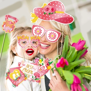 Adult and child using Mother's Day photo props like glitter hats and floral glasses