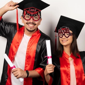 Cheerful graduates wearing red and black 2026 glitter paper party glasses decorations