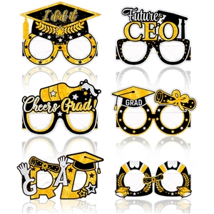 Close-up of six black and gold graduation party glasses with glittery designs and slogans