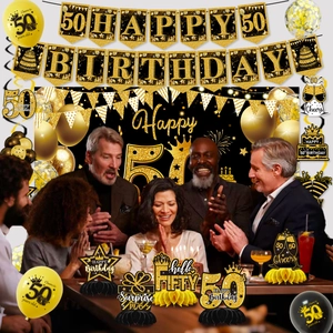 Detailed 50th birthday party set with gold and black balloons, banners, and table centerpieces