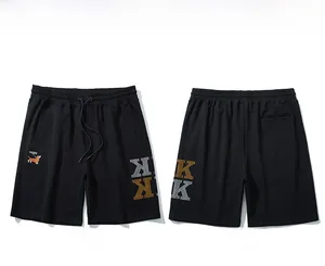 Flat lay of men's oversize black shorts featuring detailed dog embroidery and side K print