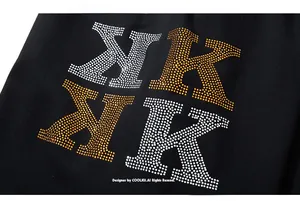 Macro view of rhinestone-studded NK letters on black knit fabric shorts