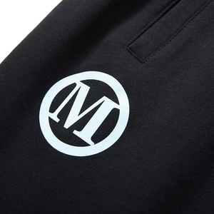 Loose fit men's athletic shorts in black cotton featuring a white circular M logo print