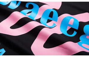 Detailed close-up of vibrant pink and blue printed graphics on black knit fabric texture