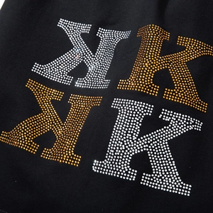 Men's oversized black shorts featuring sparkling gold and silver rhinestone NK logo embroidery