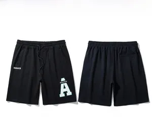 Detail of black cotton sports shorts featuring white HAGAEH letter print and drawstring waist