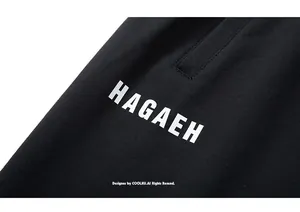 Detail of black sports shorts featuring white HAGAEH letter print and hemmed pocket