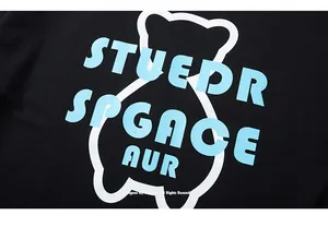 Detail of blue street-style text and bear graphic print on black cotton T-shirt