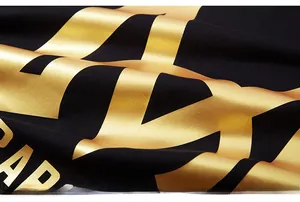 Macro detail of high-quality gold foil printing on black oversized cotton t-shirt fabric