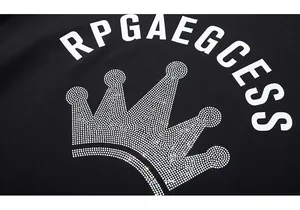 Macro view of glittering crown rhinestone pattern and RPGAEGCESS lettering on black T-shirt