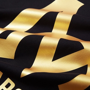 Black loose T-shirt with gold metallic printed diagonal stripes and bold letters