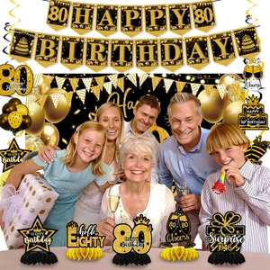 Detail of 80th birthday black and gold party set with honeycomb centerpieces and banner