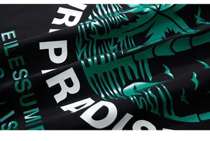 Vue macro de l'imprimé Paradise avec palmier vert sur un tissu en coton noir