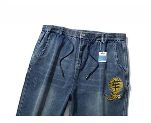 Detail view of denim jeans elastic waist with drawstring and Chinese style embroidery