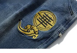 Detailed close-up of golden cloud embroidery on blue denim fabric with woven label