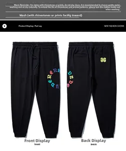 Detail of black jogger pants with elastic drawstring waist and colorful letter prints