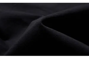 Macro shot of high-quality black knit fabric showing tight honeycomb texture and drape