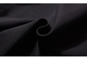 Detail of premium black knit fabric showing soft texture and dense plain weave structure