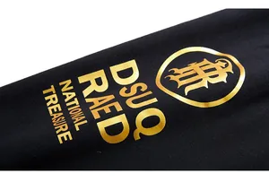 Détail de l'impression dorée haut de gamme sur le tissu noir d'un pantalon de sport chic